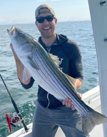 Delighted customer with a large striper in his hands