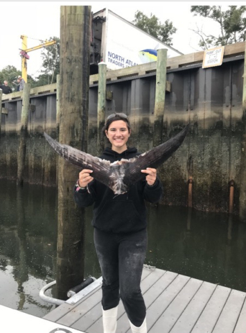 Girl holding up bluefin tuna tail