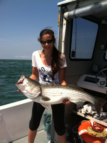 Young girl holding very large striped bass