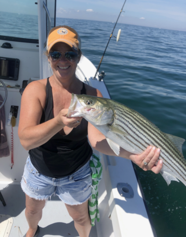 smiling woman with a gorgeous striper in hand