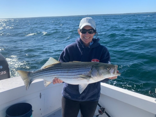 Smiling woman with large striped bass